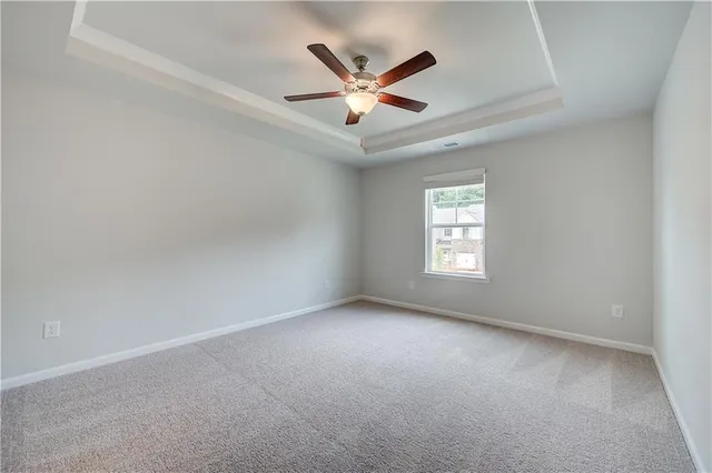 a view of an empty room and a ceiling fan
