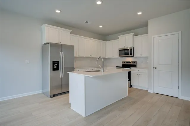 a kitchen with a refrigerator and a stove top oven
