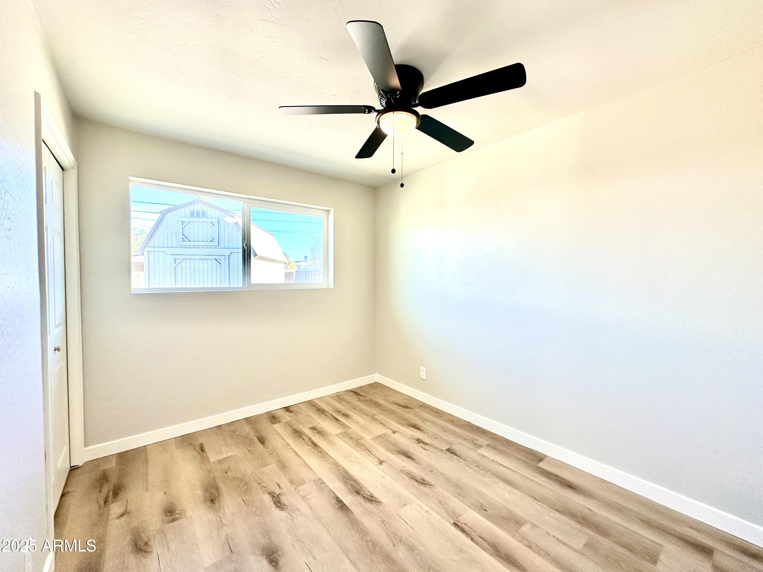 1188 North 4th Street Coolidge, AZ 85128 - Photo 14 of 26 a view of a big room with wooden floor and a ceiling fan