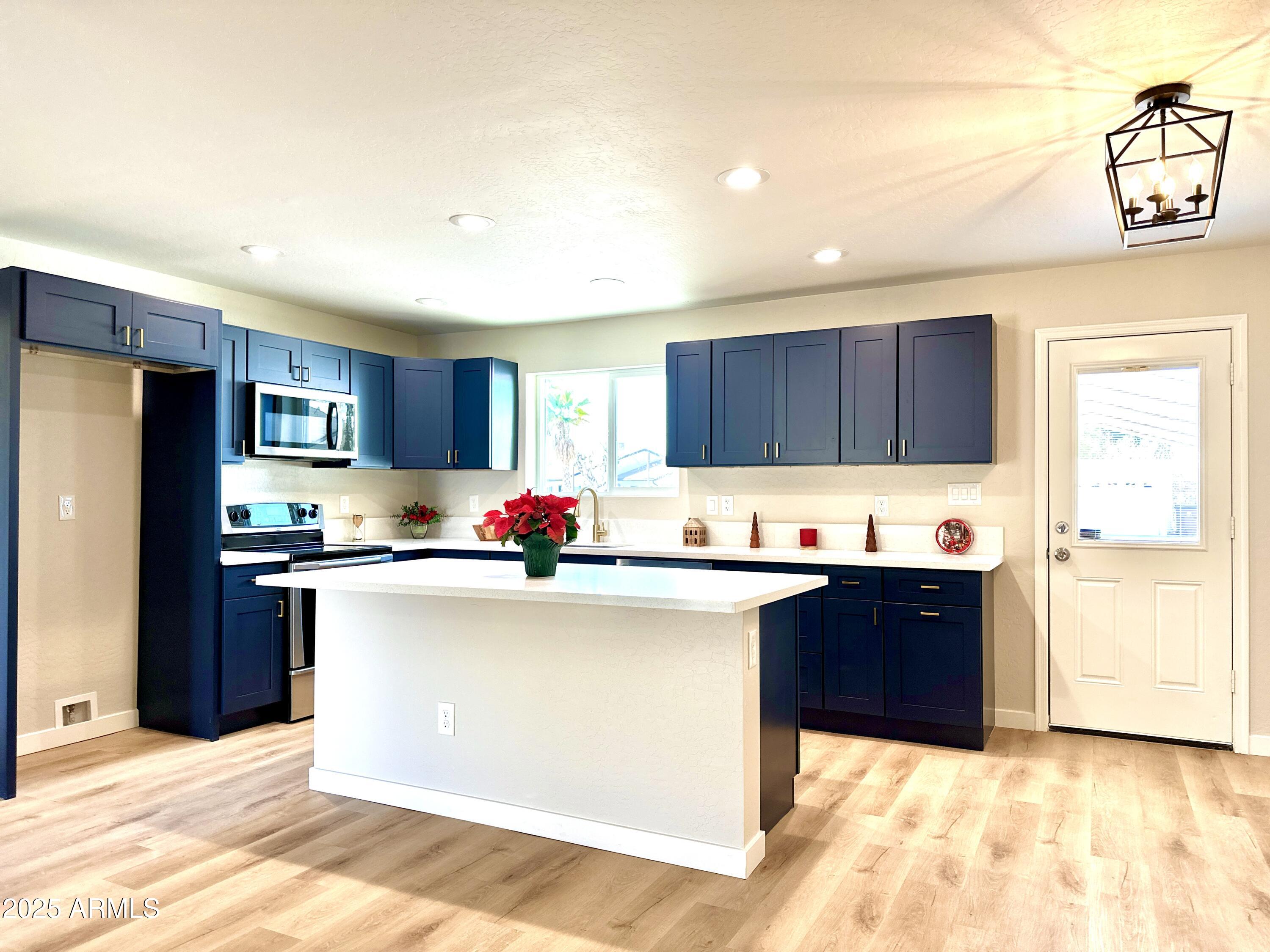 1188 North 4th Street Coolidge, AZ 85128 - Photo 5 of 26 a kitchen with granite countertop a sink and a refrigerator