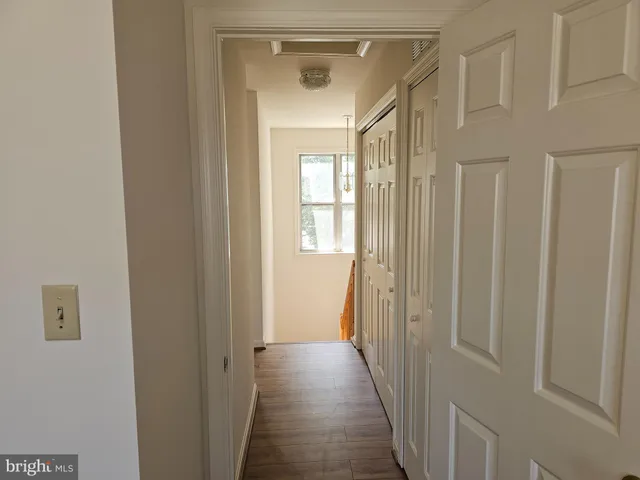 a view of a hallway with a window and a bathroom