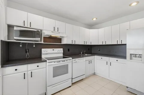 a kitchen with cabinets stainless steel appliances and sink