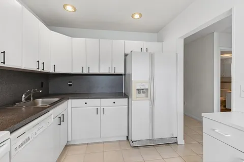 a view of cabinets a sink and a stove in a kitchen