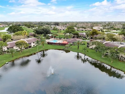 an aerial view of a house with a garden and lake view