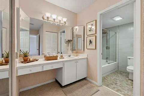 a spacious bathroom with a double vanity sink toilet and shower