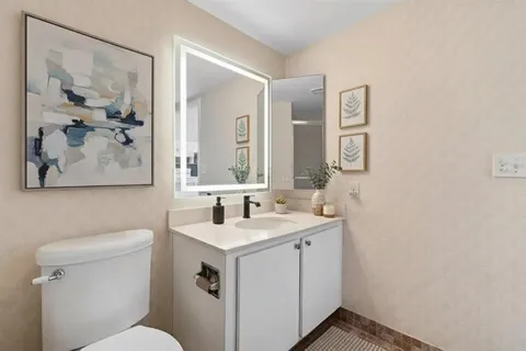a bathroom with a toilet sink and mirror