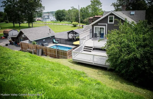 a view of a house with pool and a yard