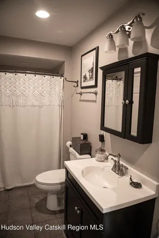 a bathroom with a sink a toilet and mirror