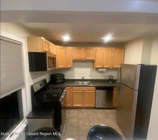 a kitchen with granite countertop a refrigerator and a stove top oven