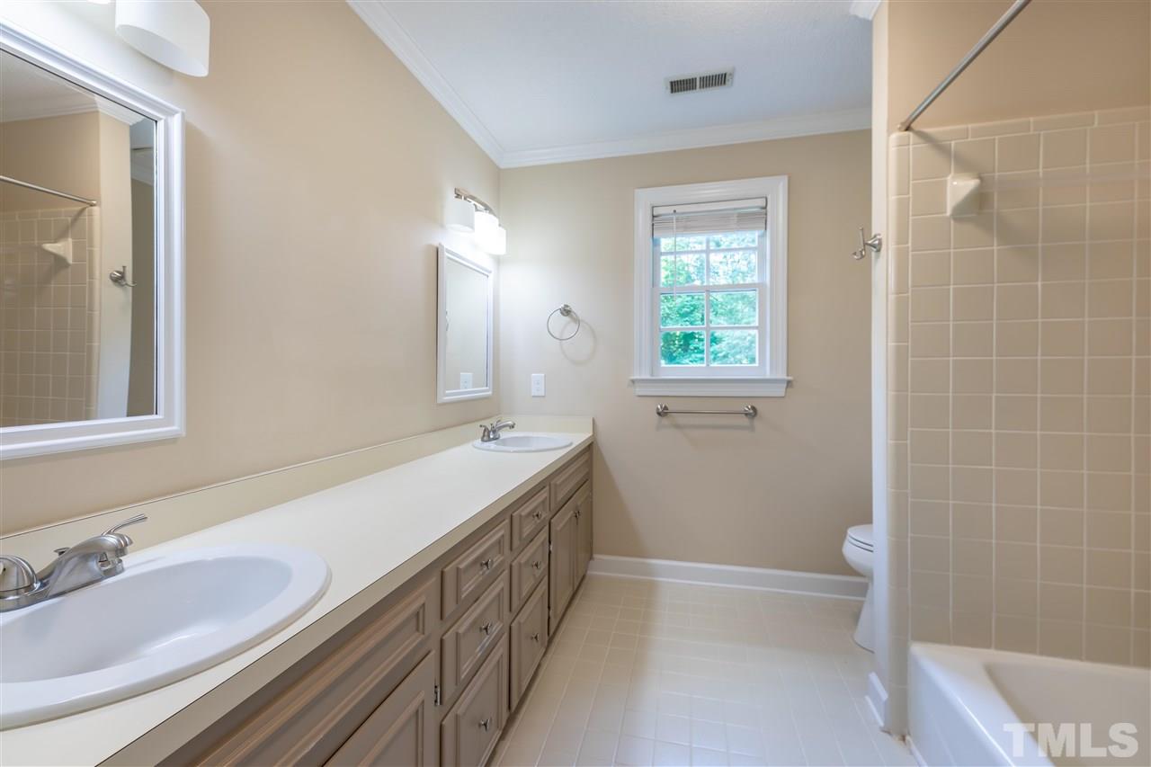 2408 Heartley Drive Raleigh, NC 27615 - Photo 11 of 26 a bathroom with a granite countertop bathtub a sink and a mirror