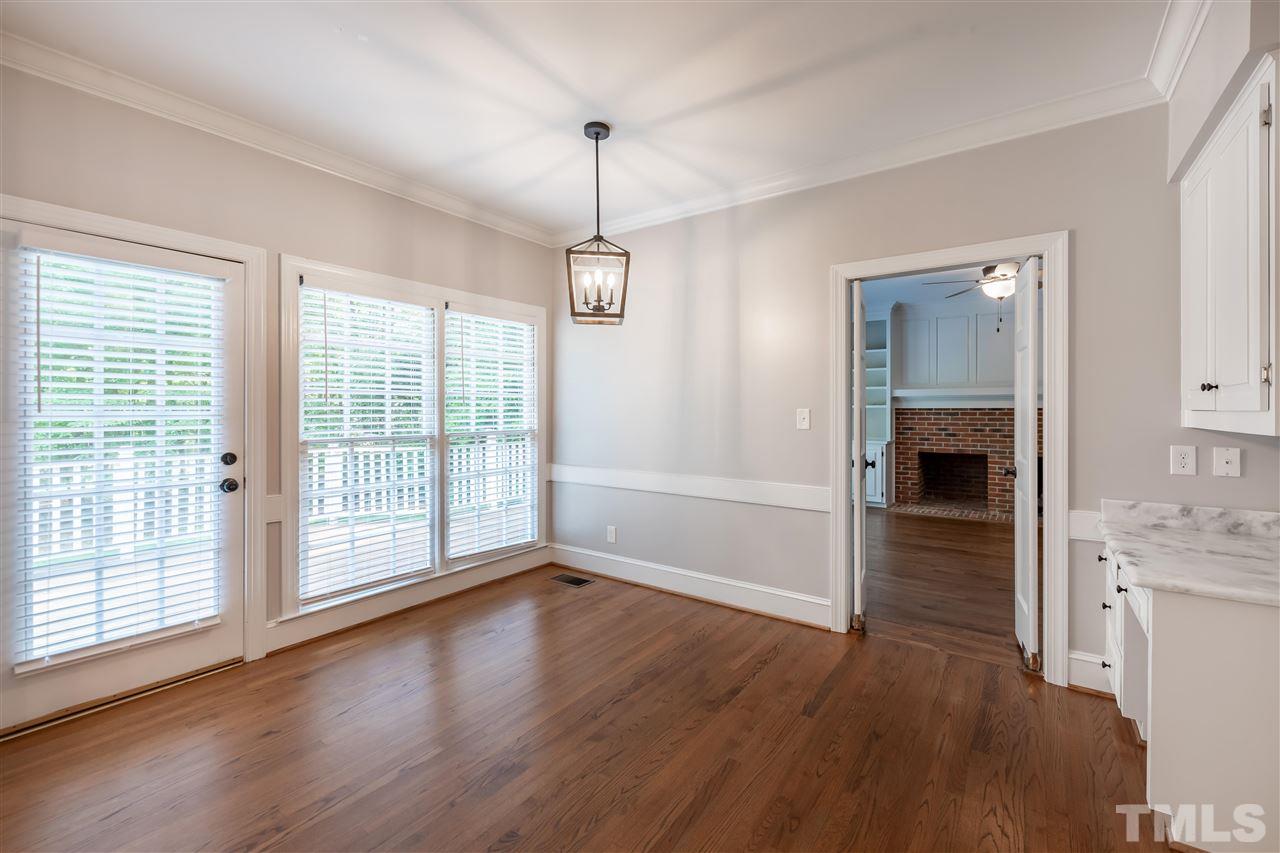2408 Heartley Drive Raleigh, NC 27615 - Photo 10 of 26 a view of empty room with wooden floor and fireplace