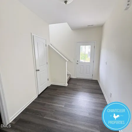 an empty room with wooden floor and mirror
