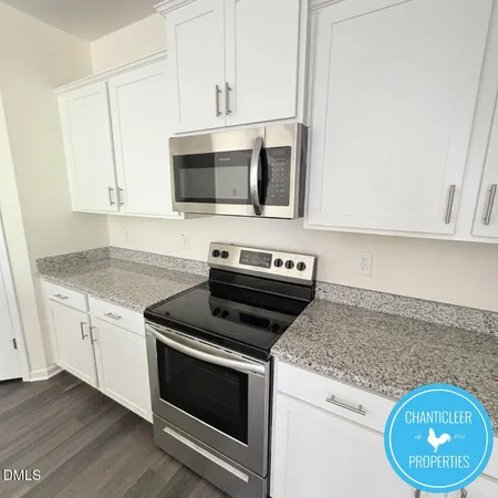 a kitchen with granite countertop cabinets stainless steel appliances and wooden floor