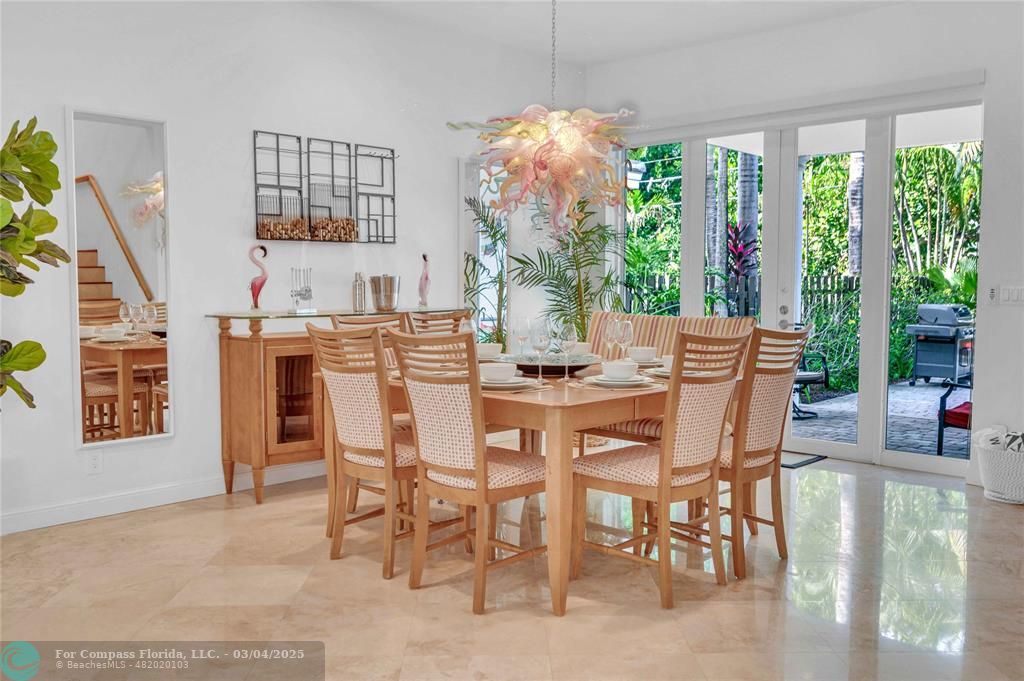 3315 Northeast 17th Street Fort Lauderdale, FL 33305 - Photo 11 of 41 a dining room with furniture large windows and a chandelier