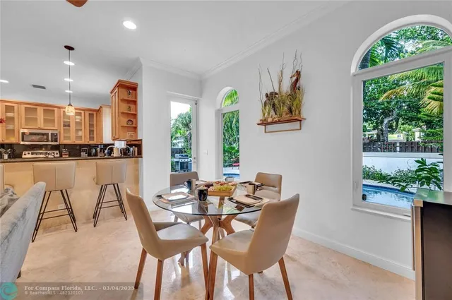 a dining room with furniture and a floor to ceiling window