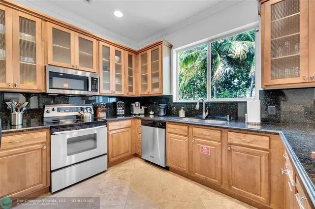 a kitchen with stainless steel appliances granite countertop a stove a sink and a microwave