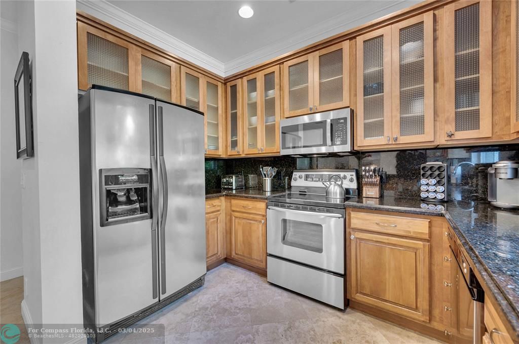 3315 Northeast 17th Street Fort Lauderdale, FL 33305 - Photo 16 of 41 a kitchen with stainless steel appliances granite countertop a refrigerator and a stove top oven