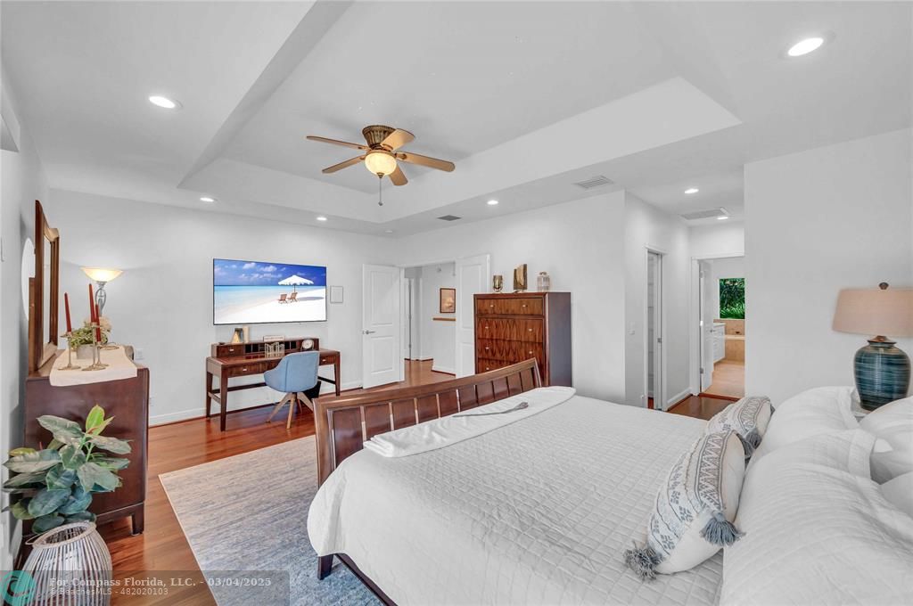 3315 Northeast 17th Street Fort Lauderdale, FL 33305 - Photo 4 of 41 a large bedroom with a bed and wooden floor