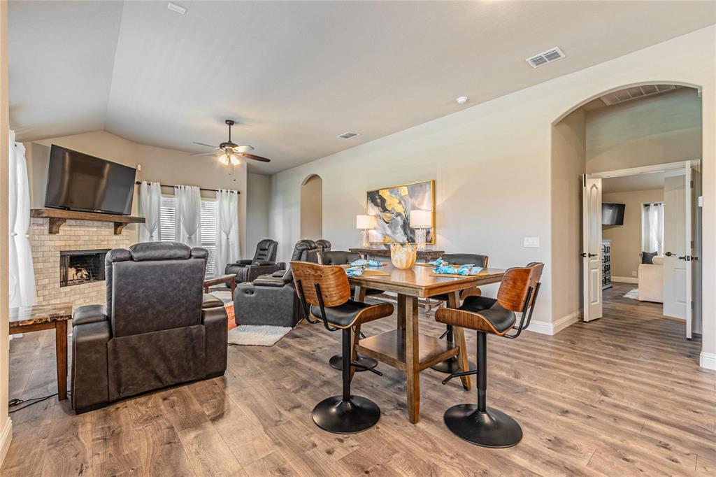 4201 Misty Ridge Street Mesquite, TX 75181 - Photo 15 of 39 Dining space with a fireplace, wood-type flooring, vaulted ceiling, and ceiling fan