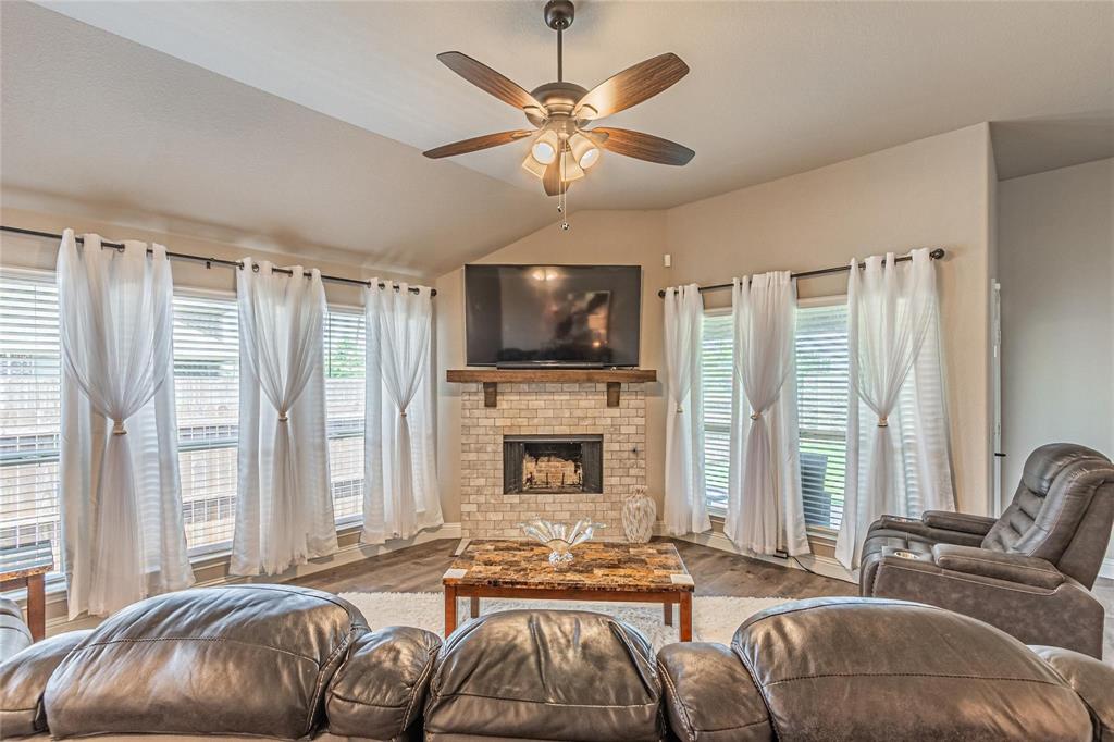 4201 Misty Ridge Street Mesquite, TX 75181 - Photo 17 of 39 Living room featuring a brick fireplace, ceiling fan, vaulted ceiling, and hardwood / wood-style flooring