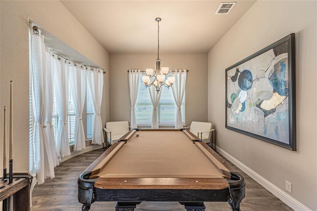 4201 Misty Ridge Street Mesquite, TX 75181 - Photo 7 of 39 Playroom featuring a healthy amount of sunlight, dark wood-type flooring, billiards, and an inviting chandelier