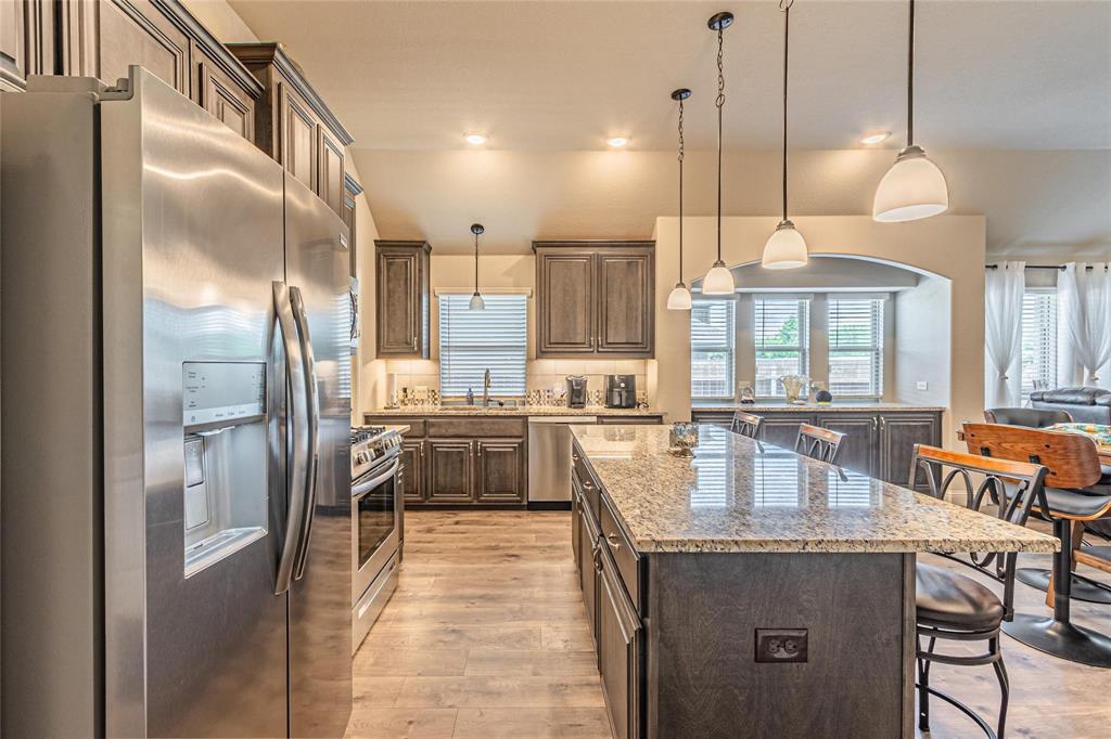 4201 Misty Ridge Street Mesquite, TX 75181 - Photo 10 of 39 Kitchen with pendant lighting, a kitchen island, light stone counters, and appliances with stainless steel finishes