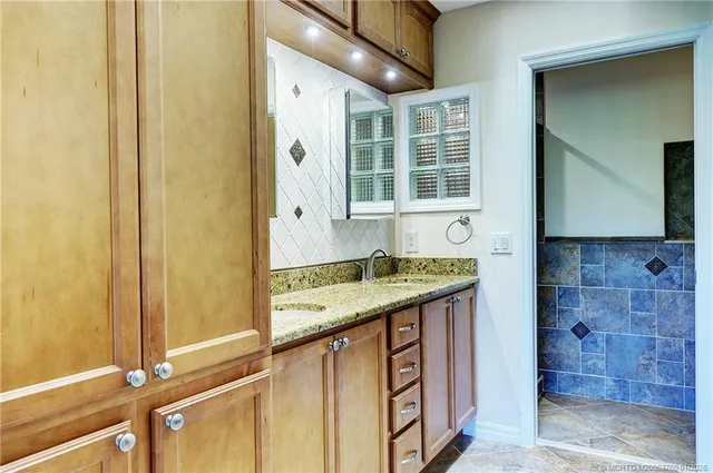 a bathroom with a granite countertop sink and a mirror