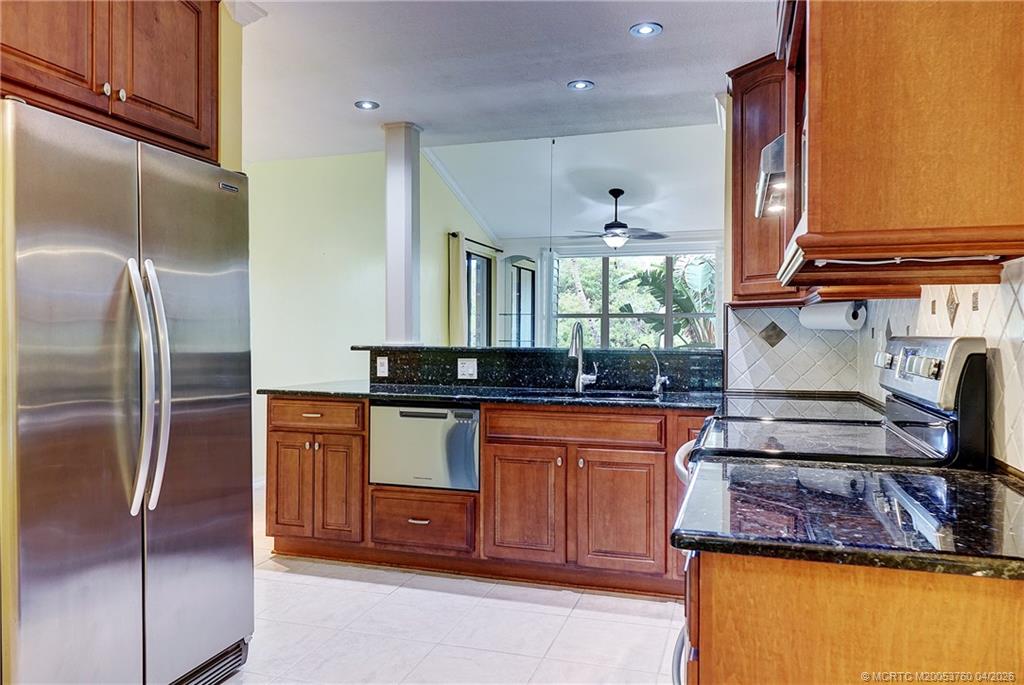 5290 Southeast Seascape Way, Unit 201 Stuart, FL 34997 - Photo 4 of 30 a kitchen with stainless steel appliances granite countertop a sink stove and refrigerator