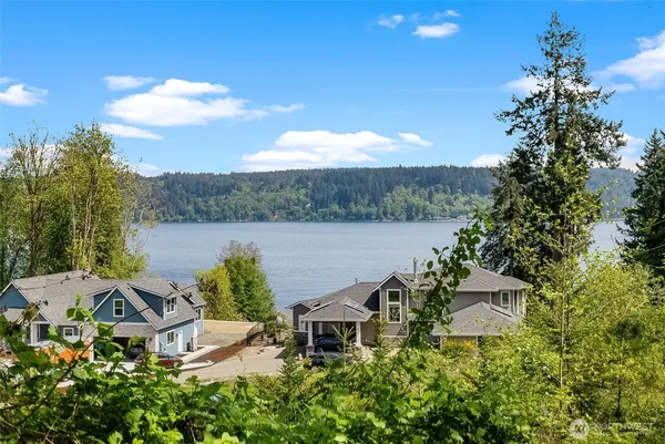 a view of a lake with couches and wooden fence