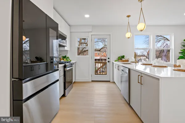 a large kitchen with stainless steel appliances kitchen island granite countertop a sink and cabinets