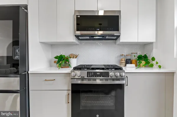 a kitchen with stainless steel appliances granite countertop a stove a microwave and cabinets