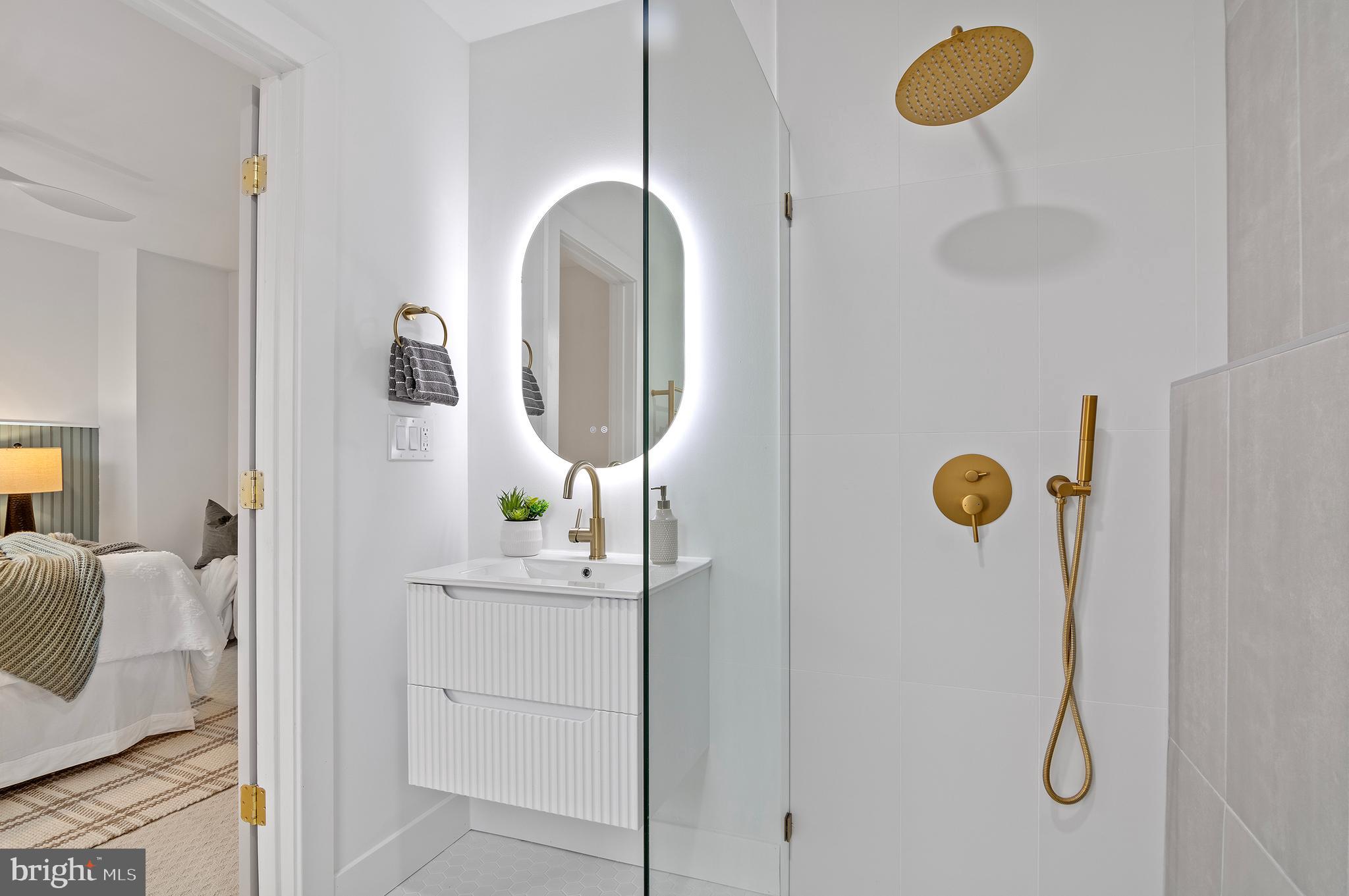 5905 Glenkirk Road Baltimore, MD 21239 - Photo 17 of 31 a bathroom with a sink a mirror and shower curtain