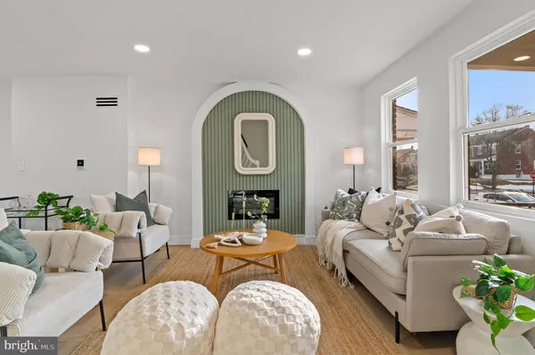 a living room with furniture a fireplace and a potted plant