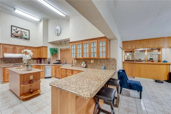 a kitchen with stainless steel appliances kitchen island granite countertop a refrigerator and cabinets