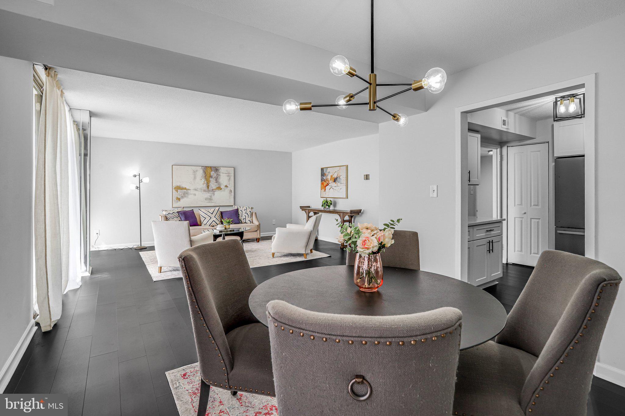 1836 Metzerott Road, Unit 627 Adelphi, MD 20783 - Photo 12 of 27 a living room with furniture a dining table and a chandelier
