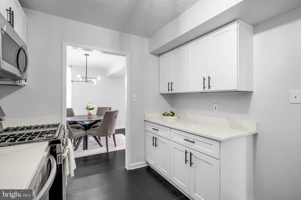 a kitchen with white cabinets and sink
