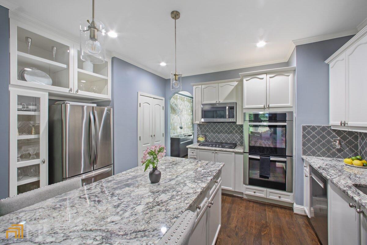 a kitchen with stainless steel appliances granite countertop a refrigerator and stove
