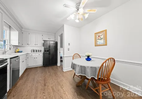 a kitchen with stainless steel appliances a stove a sink a dining table and chairs