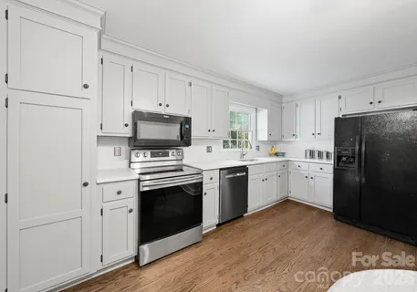 a kitchen with a refrigerator stove and white cabinets