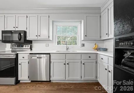 a kitchen with white cabinets and a stove