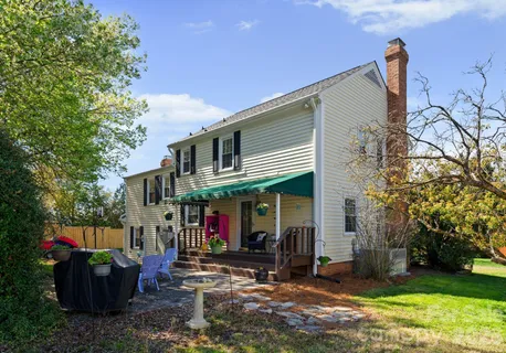a view of a house with backyard and sitting area