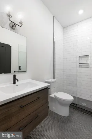 a bathroom with a double vanity sink toilet and mirror