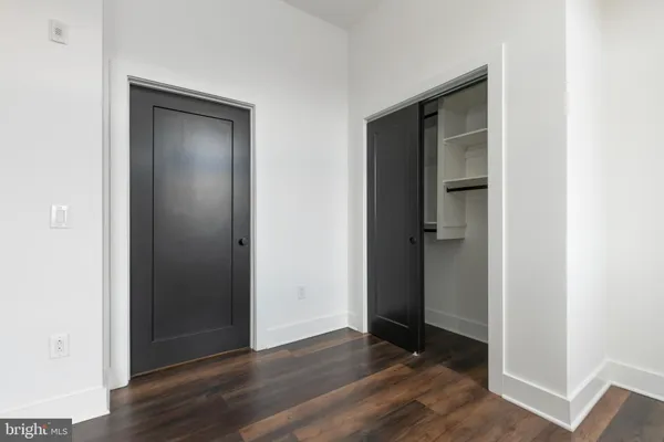 an empty room with wooden floor & closet