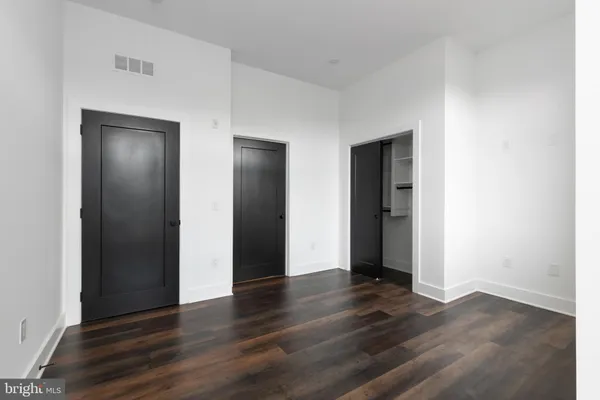 an empty room with wooden floor and closet
