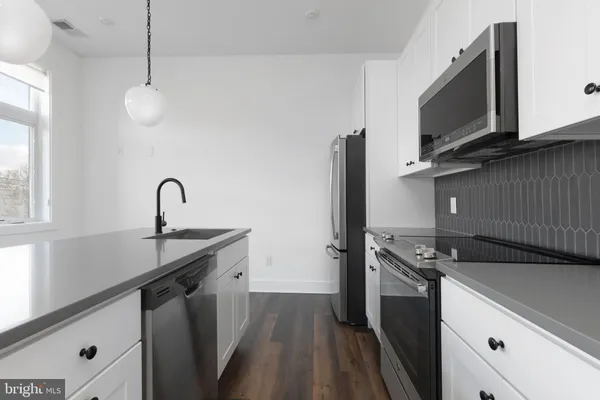 a kitchen that has a sink stainless steel appliances and cabinets
