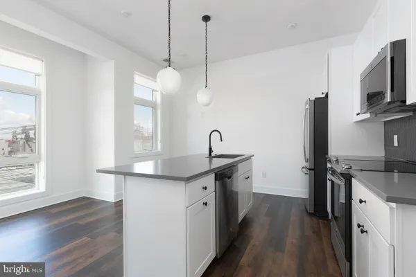 a kitchen with sink stove and refrigerator