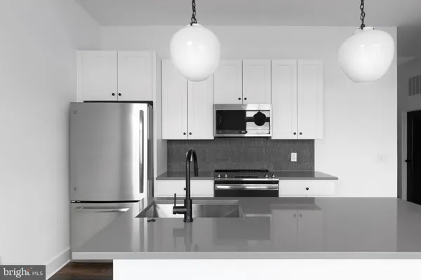 a kitchen with kitchen island a refrigerator a stove a microwave and cabinets