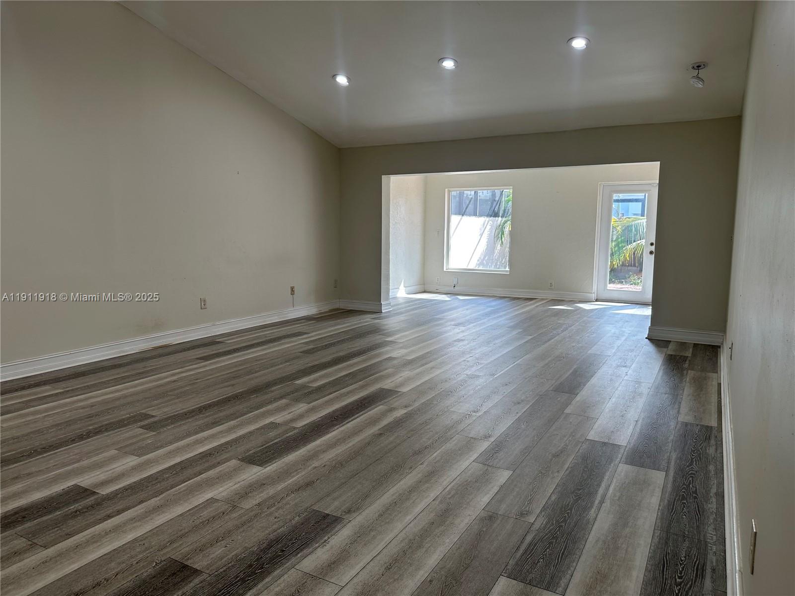 11354 Southwest 87th Terrace, Unit 11354 Miami, FL 33173 - Photo 14 of 25 an empty room with wooden floor and windows