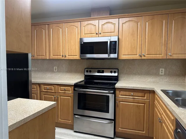 a kitchen with stainless steel appliances granite countertop a stove microwave and cabinets