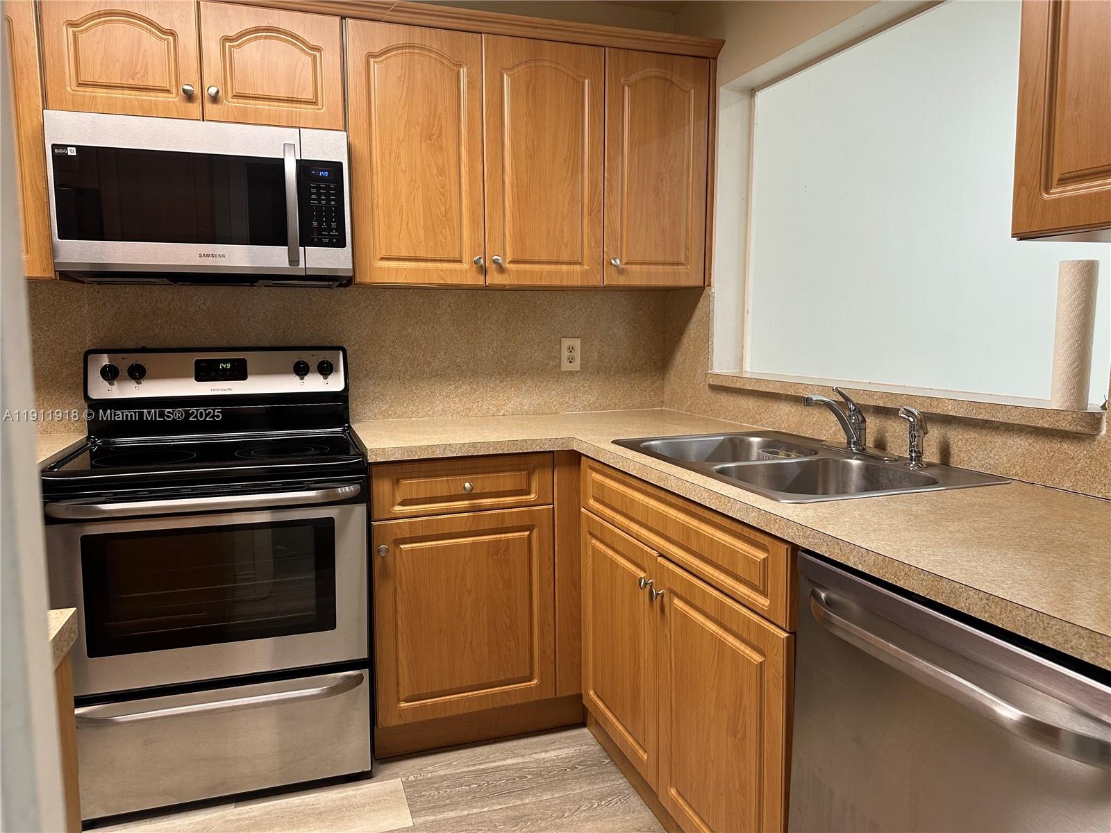 11354 Southwest 87th Terrace, Unit 11354 Miami, FL 33173 - Photo 19 of 25 a kitchen with a sink stove and microwave